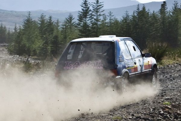 Tyre and Auto Rally Team car throwing up gravel on a forest stage